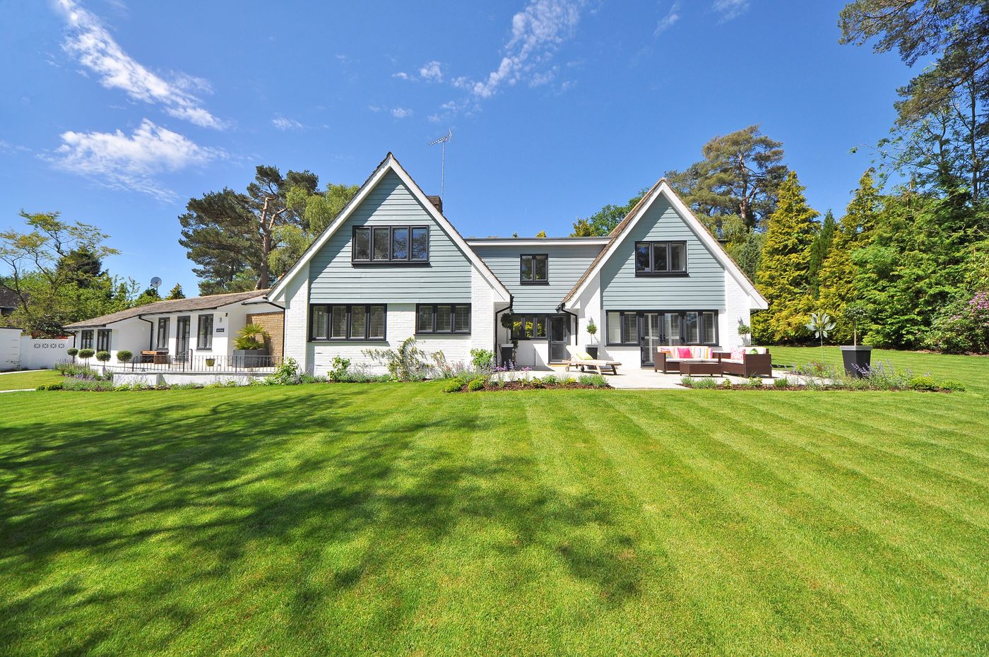 A striped, freshly cut lawn in front of a house